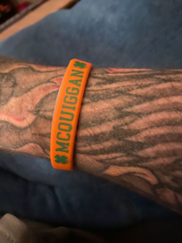 person wearing orange wristband with a name