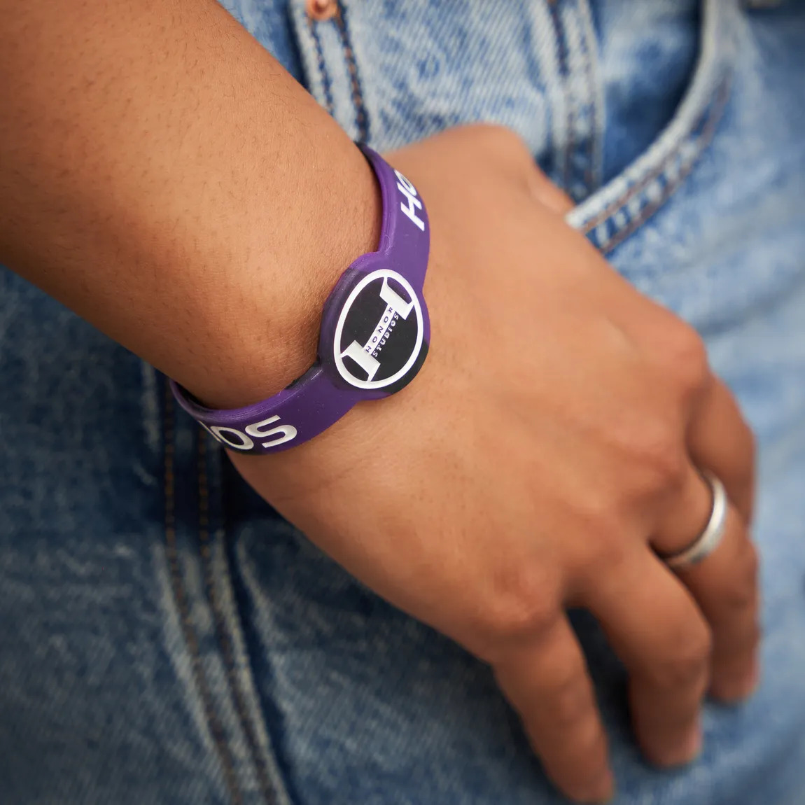 person wearing rubber bracelet with symbol