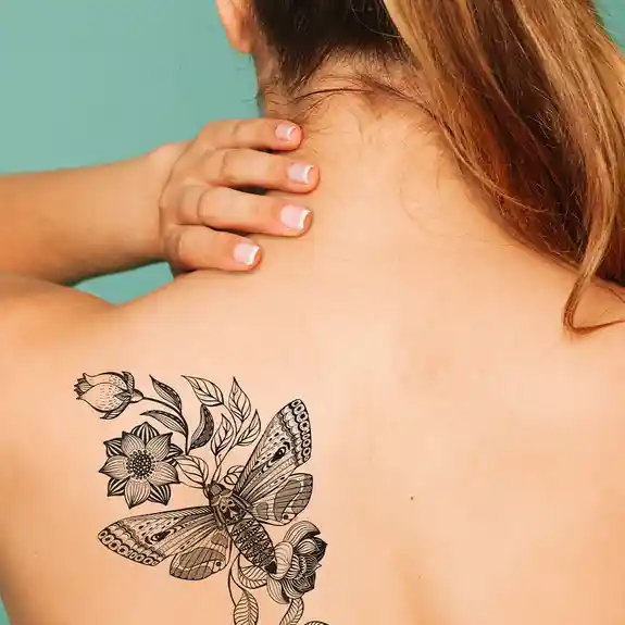 Black custom tattoo of butterfly with botanical flowers