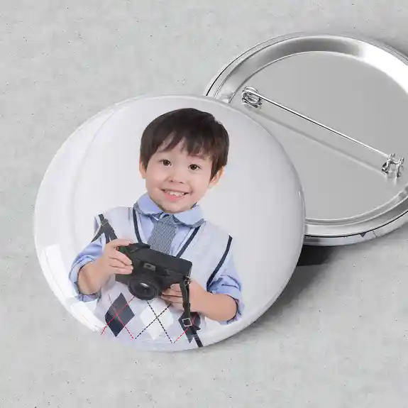 Round photo button pin of boy with camera