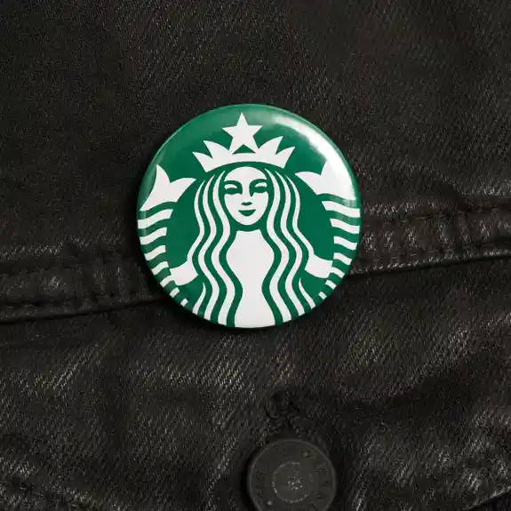 Starbucks logo button pinned on black denim jacket