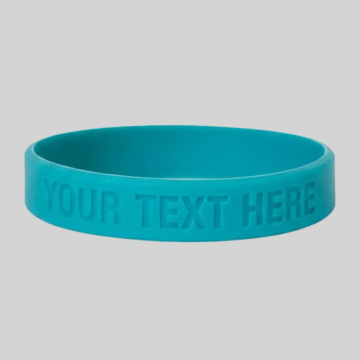 A teal silicone wristband with a sunken, debossed "YOUR TEXT HERE" imprint.